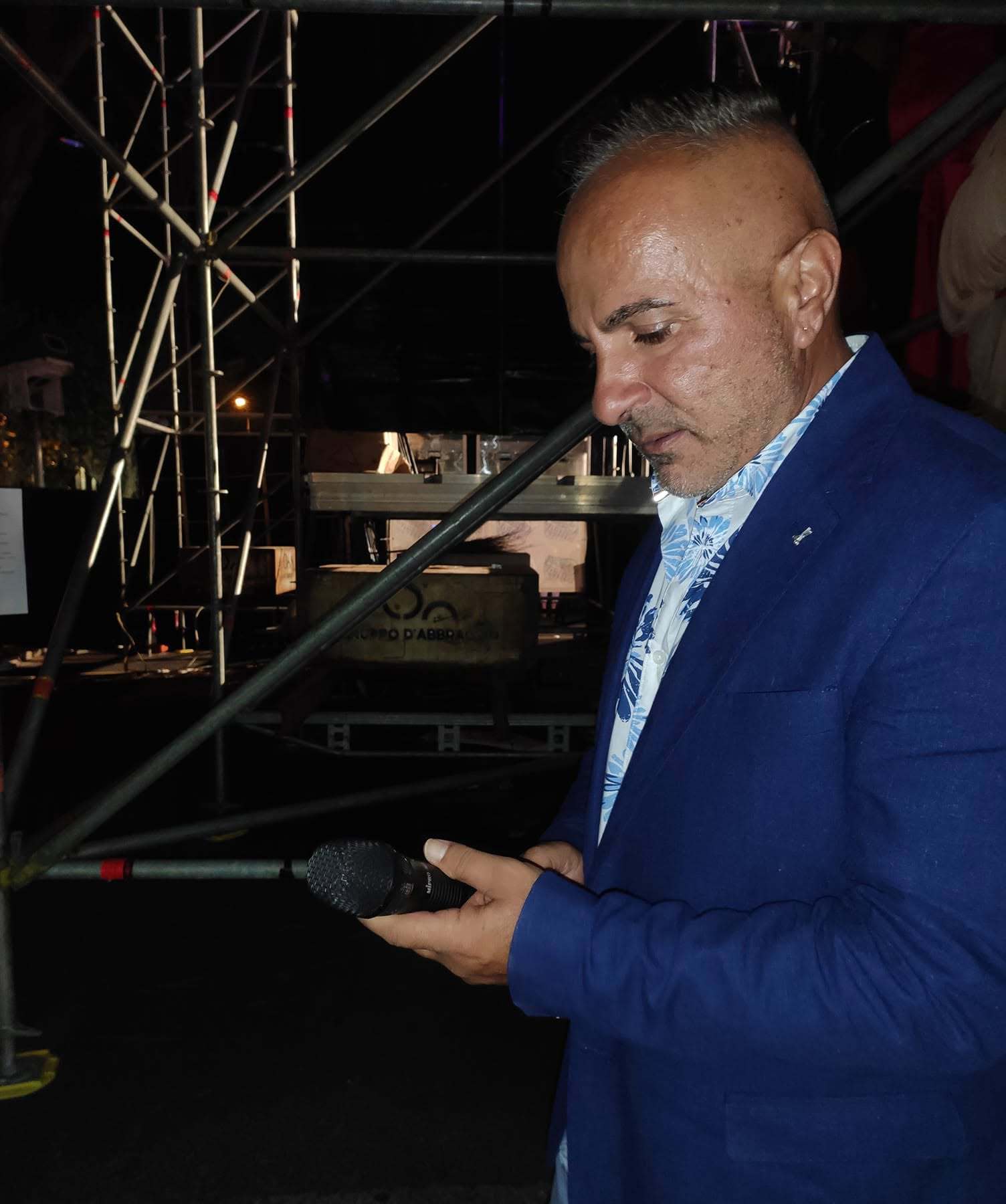 Massimiliano Di Vanni si esibisce dal vivo con il microfono durante una serata